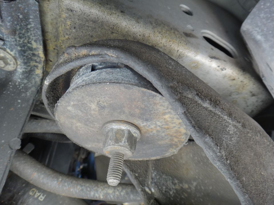 Close-up of a rubber and metal suspension bushing with a bolt