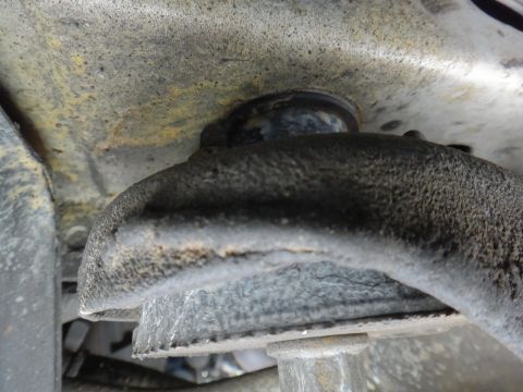 2000 Lincoln Continental - This image shows a close-up view of a vehicle's suspension system, focusing on a rusty metal component.
