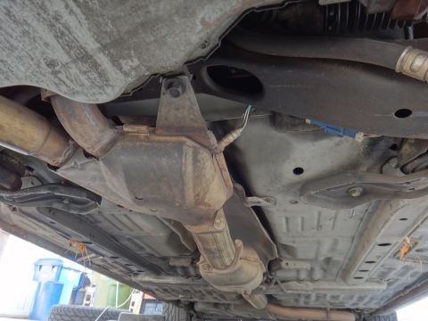 2000 Lincoln Continental - The underside of a vehicle reveals the exhaust system, catalytic converter, and suspension parts, suggesting a focus on mechanical componen…