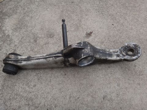2000 Lincoln Continental - A used suspension control arm is shown against a concrete background.