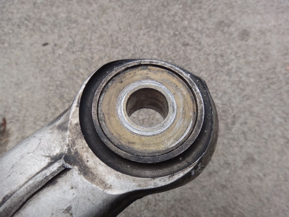 Close-up of a worn suspension bushing with metal and rubber components
