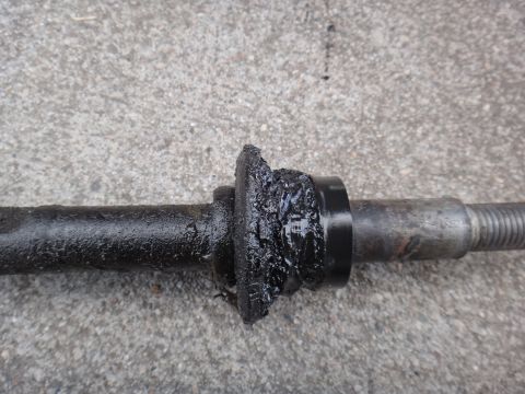 2000 Lincoln Continental - A heavily worn and greased suspension bushing is shown on a metal shaft, indicating a need for replacement.