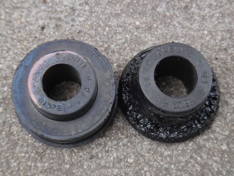 2000 Lincoln Continental - Two rubber suspension bushings are shown, one in better condition than the other, against a concrete background.