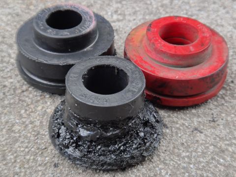 2000 Lincoln Continental - These suspension bushings show significant wear and tear, with one appearing to be coated in debris.