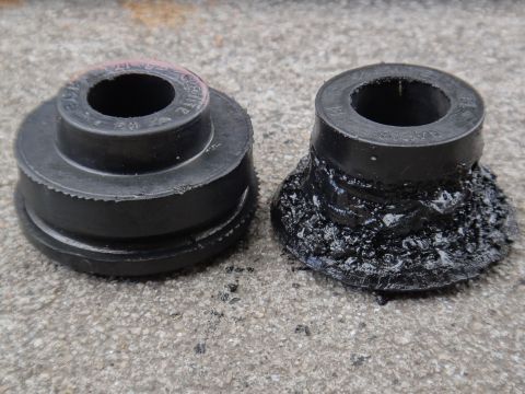 2000 Lincoln Continental - Comparison of a new suspension bushing next to a severely degraded and melted one, indicating wear and tear.