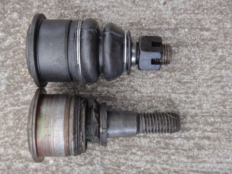 2000 Lincoln Continental - Comparison of a new ball joint with a worn one, highlighting the difference in condition and potential failure.