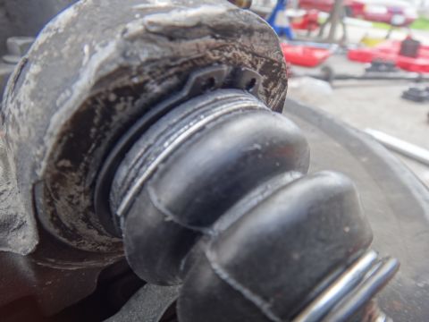 2000 Lincoln Continental - A close-up view of a worn rubber suspension boot, likely needing replacement.