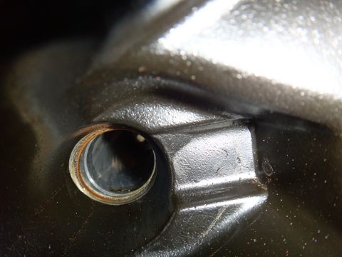 2000 Lincoln Continental - Detail of a dark, metallic component a circular aperture and signs of wear.