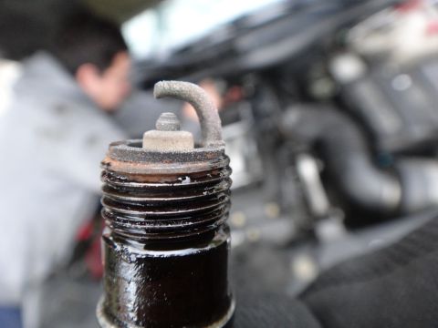 2000 Lincoln Continental - A close-up view of a spark plug shows significant wear and carbon buildup, indicating potential engine issues.