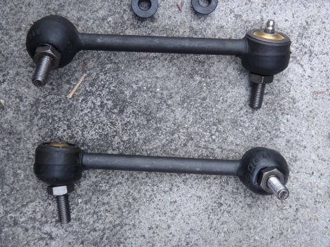 2000 Lincoln Continental - Two sway bar links, likely for a vehicle's suspension system, are shown laid out on a concrete surface.