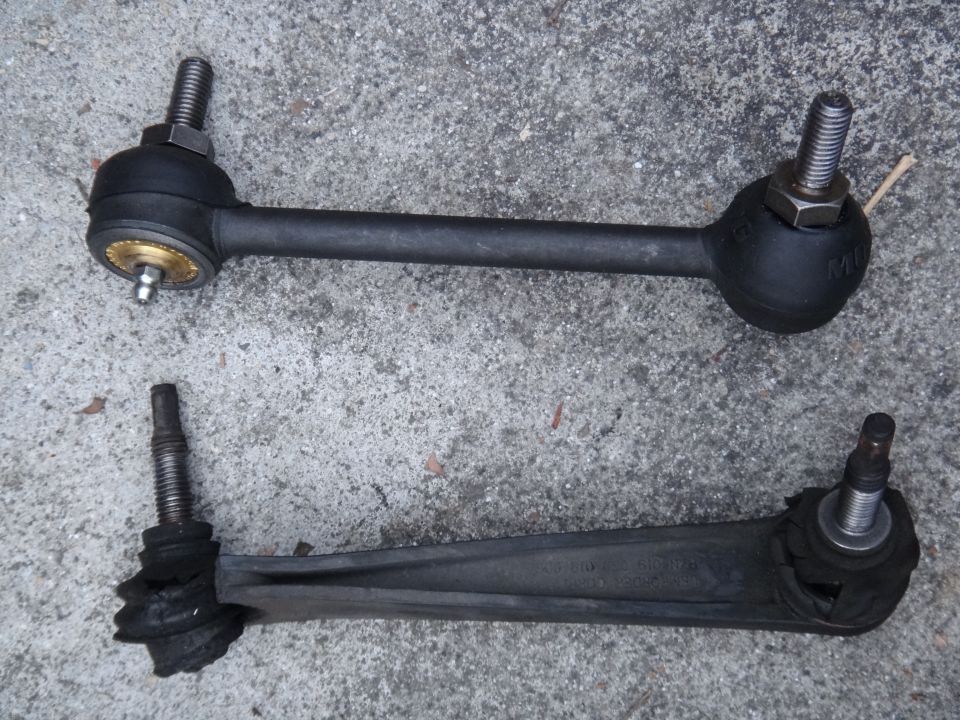 Two car suspension stabilizer links, one appears new, the other worn