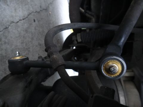 2000 Lincoln Continental - This image shows a close-up view of a vehicle's suspension system, specifically focusing on a tie rod end and a brake hose.