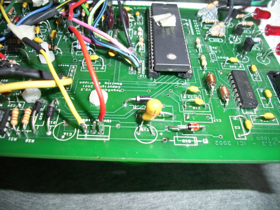 Circuit board with red, yellow, and blue wires connected to chips and resistors. Copyright 2001 text visible