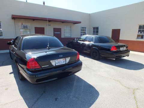2003 Ford Crown Victoria - Black Crown Victoria, plate 6YKS138, photographed from the rear with a second sedan in the lot.