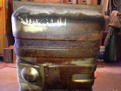 1979 Ford Bronco - This heavily rusted fuel tank shows significant wear and tear, with liquid drips evident.