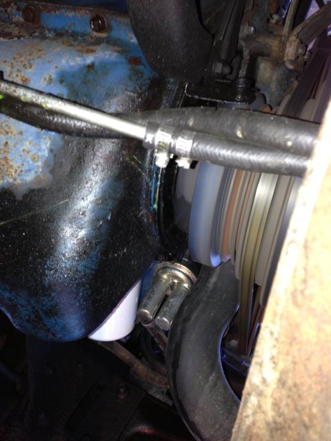 1979 Ford Bronco - Close-up view of an engine oil filter and hoses, showing signs of fluid leakage.