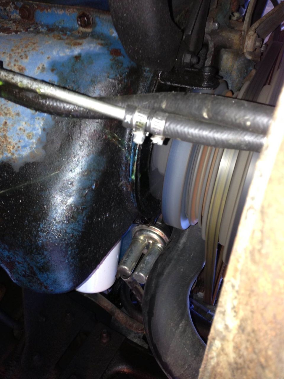 Engine oil filter and hoses with visible fluid leaks