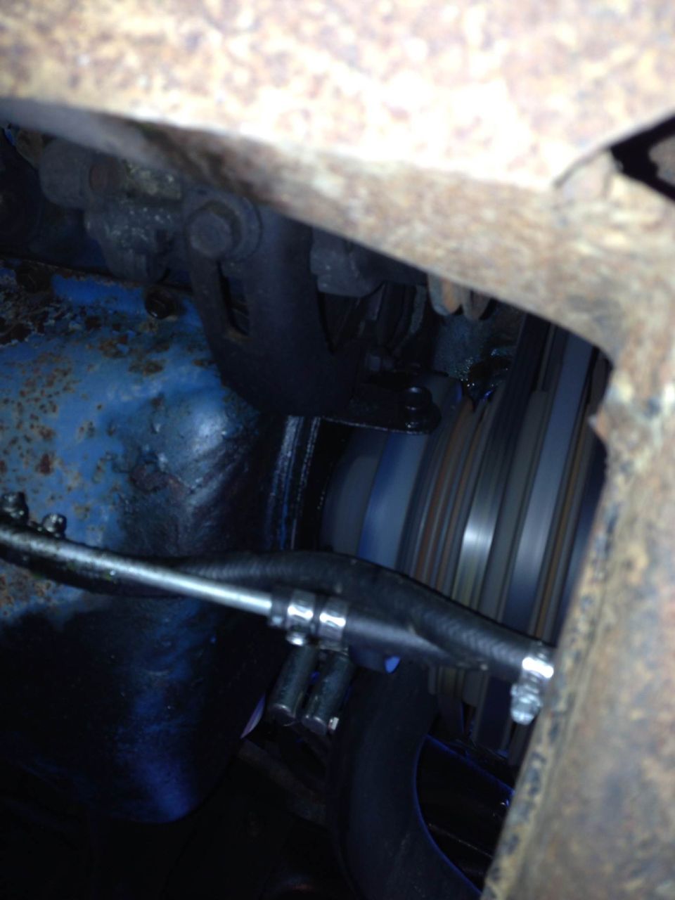 Engine belt and pulley system with blue painted engine block visible