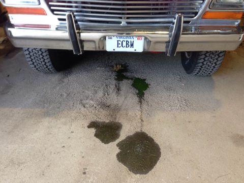 1979 Ford Bronco - A 1979 Ford Bronco shows a leak of green fluid on the ground beneath its front end.