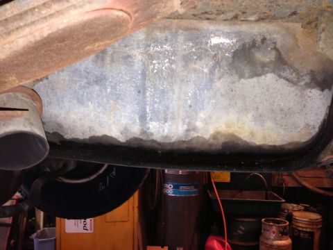 1979 Ford Bronco - Close-up of vehicle undercarriage, focusing on exhaust and tire area, with visible rust.
