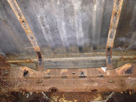 1979 Ford Bronco - The underside of this vehicle shows significant rust on the frame and bed supports, indicating extensive wear.