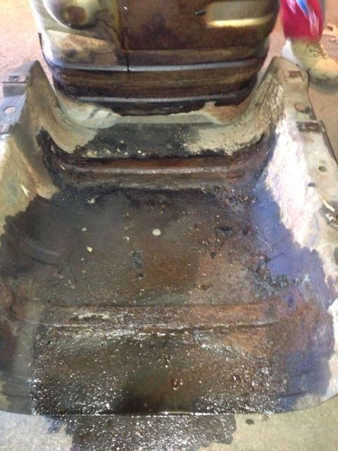 1979 Ford Bronco - Close-up of a heavily corroded vehicle frame section, showing significant rust and accumulated grime.
