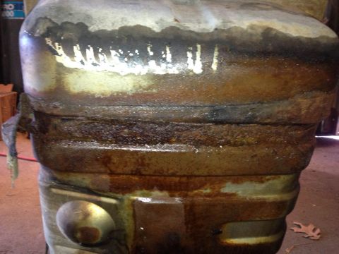 1979 Ford Bronco - A close-up view of a corroded metal part, showing extensive rust and dirt accumulation.