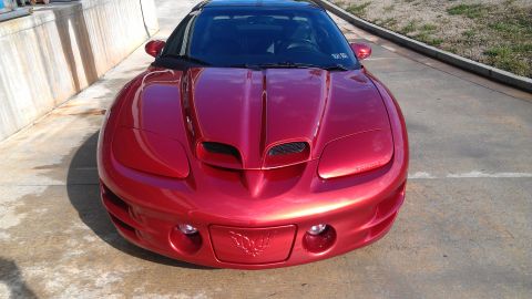 1979 Chevrolet Camaro - Front view of a red Pontiac Firebird.