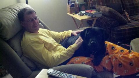 1995 Ford Bronco - Man relaxes on a couch with his black lab puppy.