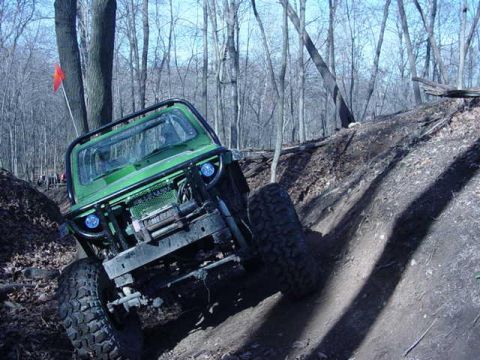 1992 Ford Bronco - This off-road Jeep navigates a challenging incline on a wooded trail, its capabilities.