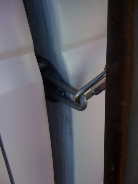 1986 Yugo GV - A close-up view of a metal chain and latch mechanism on the interior of a vehicle door.