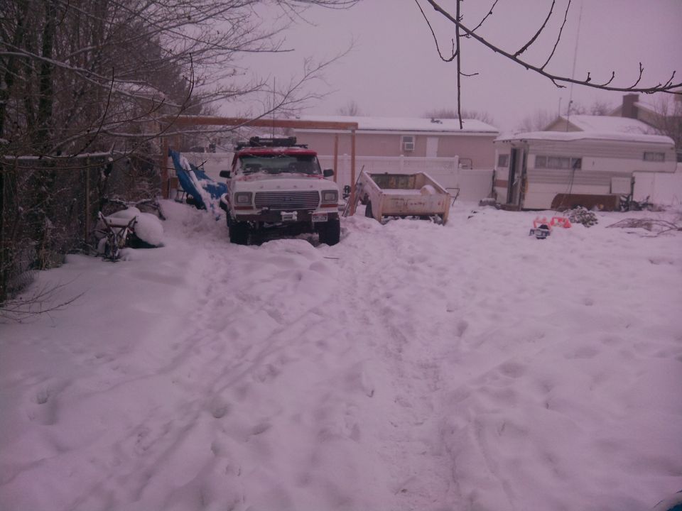 1979 Ford Bronco in snow, front view, white with red trim, roof rack, some snow on windshield