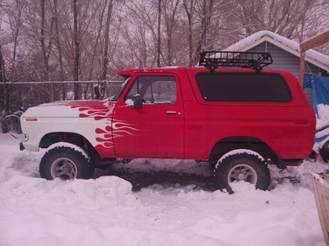 1979 Ford Bronco - Ford Bronco with flame decals stuck in deep snow, winter scene.