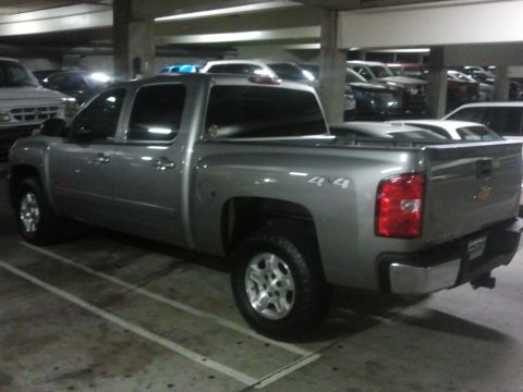 2004 GMC Sierra 1500 - A silver pickup truck is parked in a dimly lit garage, with other vehicles visible in the background.