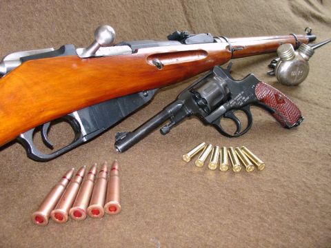 2003 Ford Crown Victoria - A collection of firearms and ammunition is displayed on a textured background.