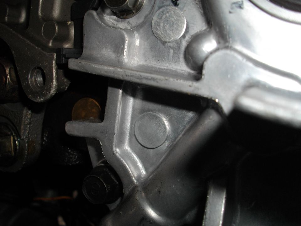 Close-up of engine component with a coin lodged in a crevice