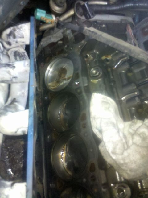 1996 Ford Bronco - Close-up of an engine block showing pistons and a damaged gasket, with the Supermotors.net logo in the corner.