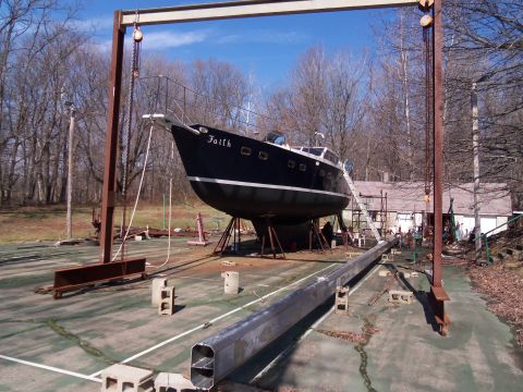 1989 Ford Bronco - A black sailboat named Faith is positioned on a dry dock with a large metal structure overhead.