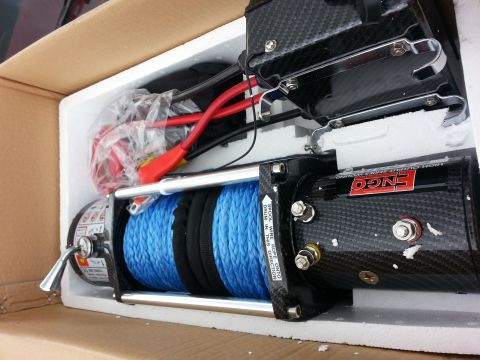 1978 Ford Bronco - A new winch, likely for off-road use, is unpacked and ready for installation.