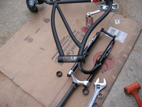 1994 Ford Bronco - Disassembled bicycle frame and fork components laid out on cardboard with tools nearby.