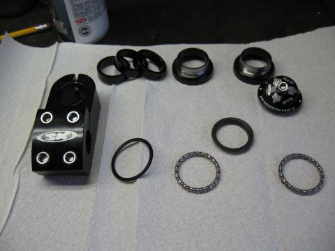 1994 Ford Bronco - Various bicycle headset parts, including a stem, bearings, and seals, are arranged on a white surface.