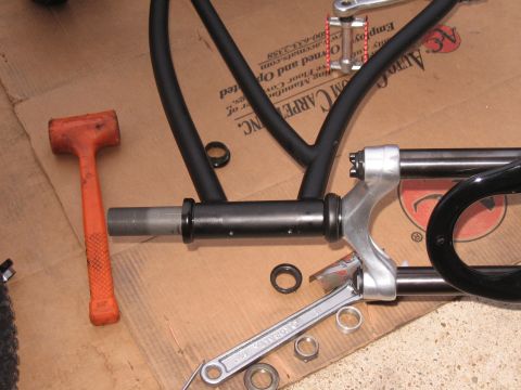 1994 Ford Bronco - Tools and parts laid out on cardboard for bicycle frame assembly or repair.