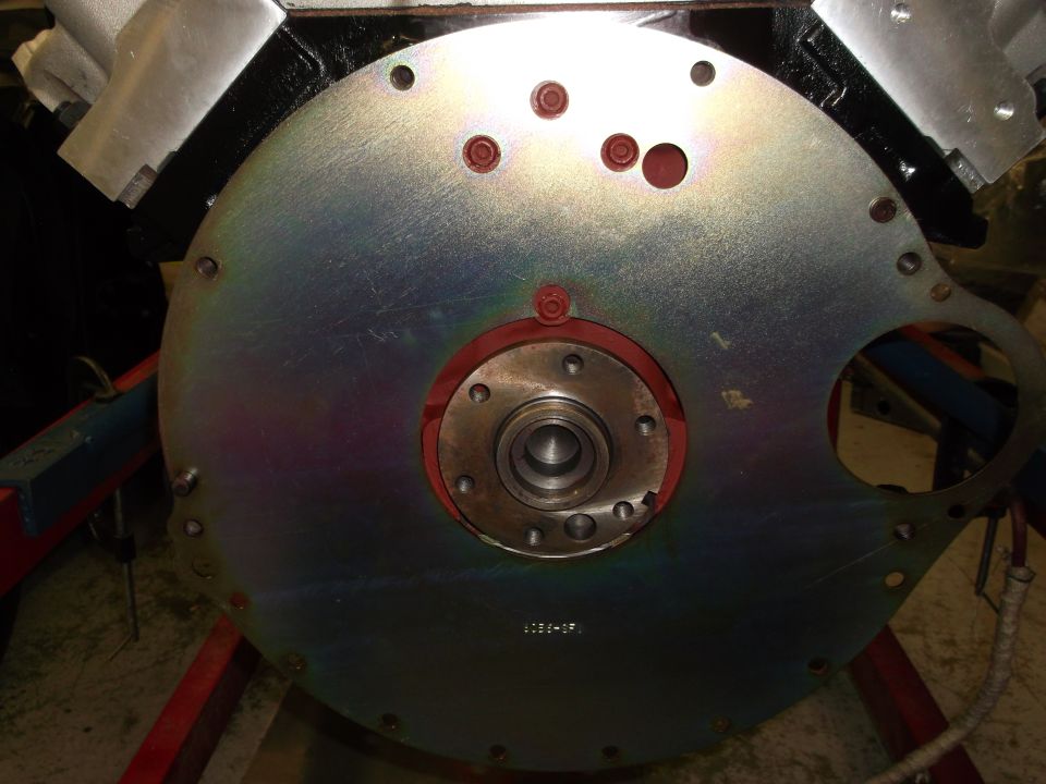 Engine flywheel with red gasket and center bearing, part number 1036-07 visible