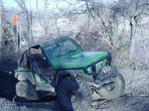 1992 Ford Bronco - This off-road vehicle is navigating a muddy trail surrounded by bare trees.