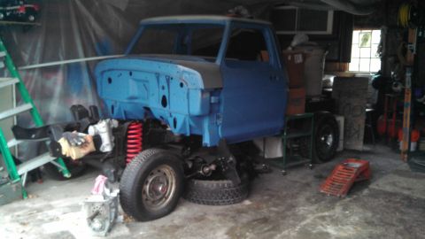 1977 Ford F-150 - A blue 1977 Ford F-150 pickup truck is shown in a garage, undergoing restoration with its chassis and cab separated.