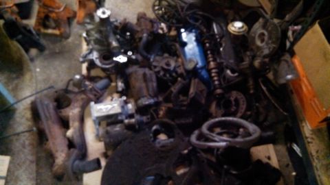 1977 Ford F-150 - Assorted engine parts are piled together, obscuring any specific vehicle identification.