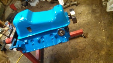 1977 Ford F-150 - A bright blue engine block is mounted on a red engine stand, likely awaiting installation or further work.