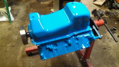 1977 Ford F-150 - Engine oil pan painted bright blue, mounted on an engine stand.