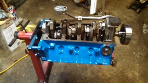 1977 Ford F-150 - A Ford V8 engine block, painted blue, is shown on an engine stand with its internal components visible.