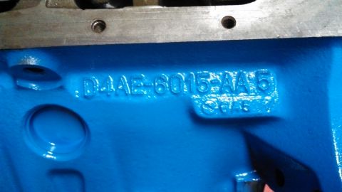 1977 Ford F-150 - Close-up of a blue engine block showing casting numbers D4AE-6015-AA5 and other markings.